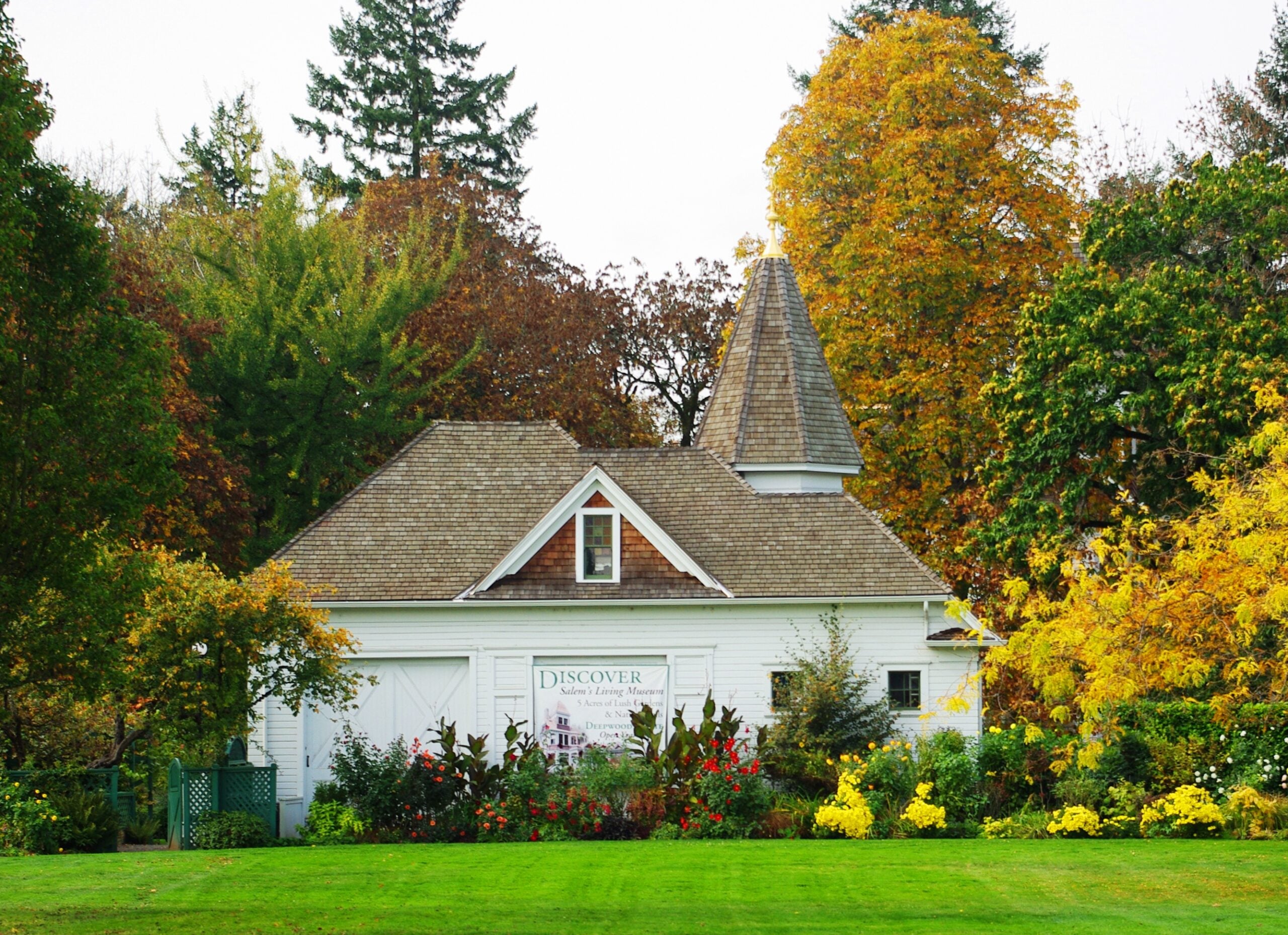 Deepwood carriage house with a pointed tower and autumn trees