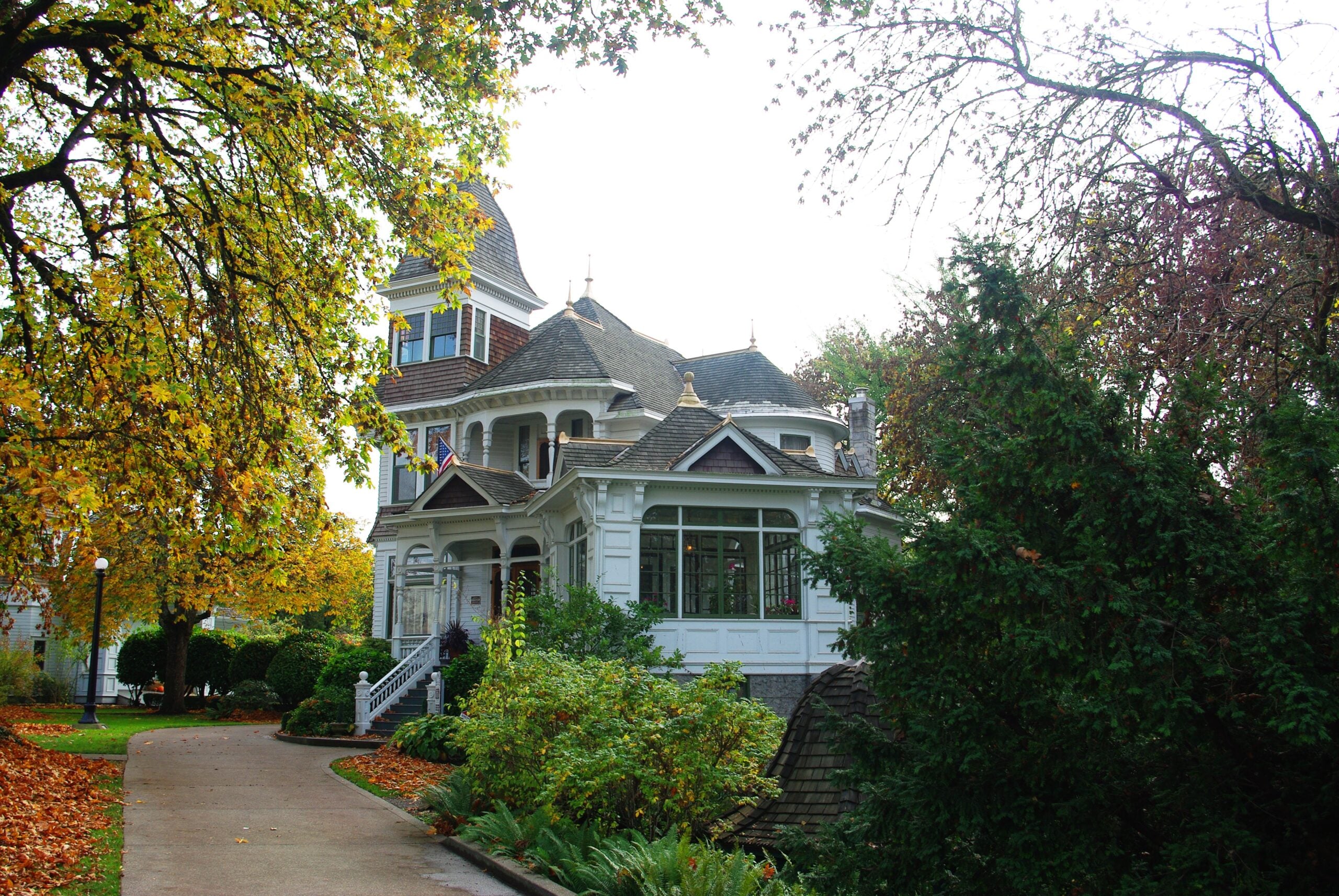 Deepwood house from garden side in autumn Deepwood's Queen Anne house and sunroom seen from a path beneath autumn trees