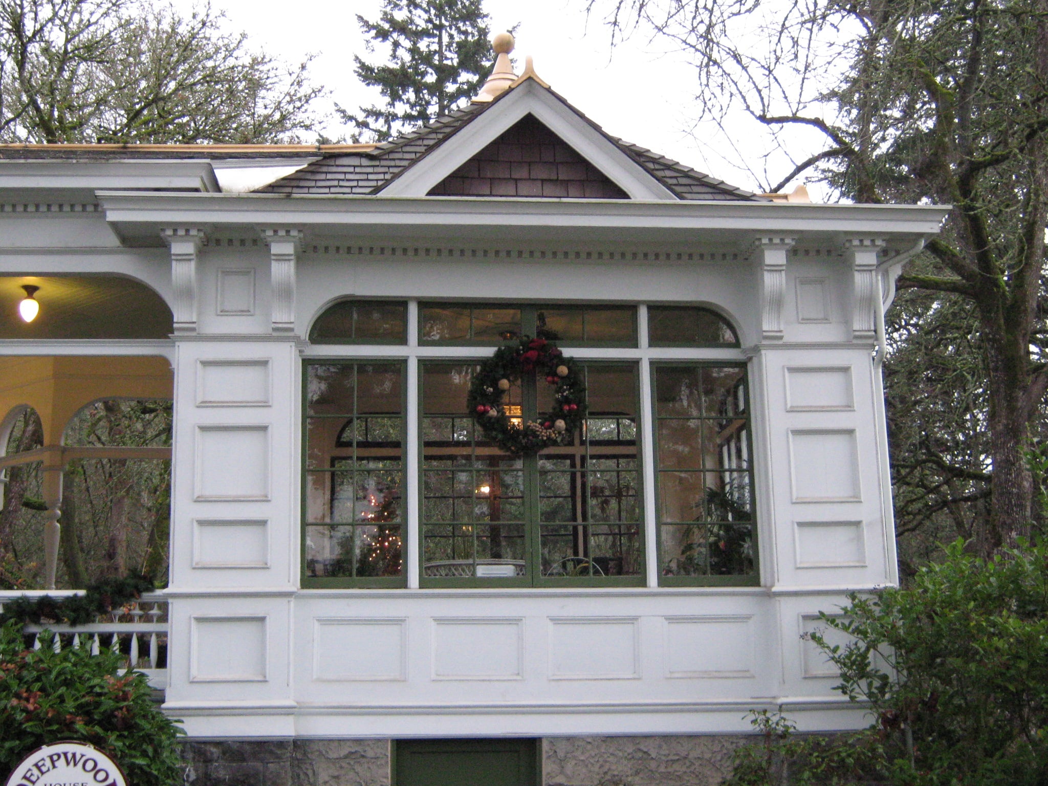White sunroom exterior at Deepwood decorated with a holiday wreath