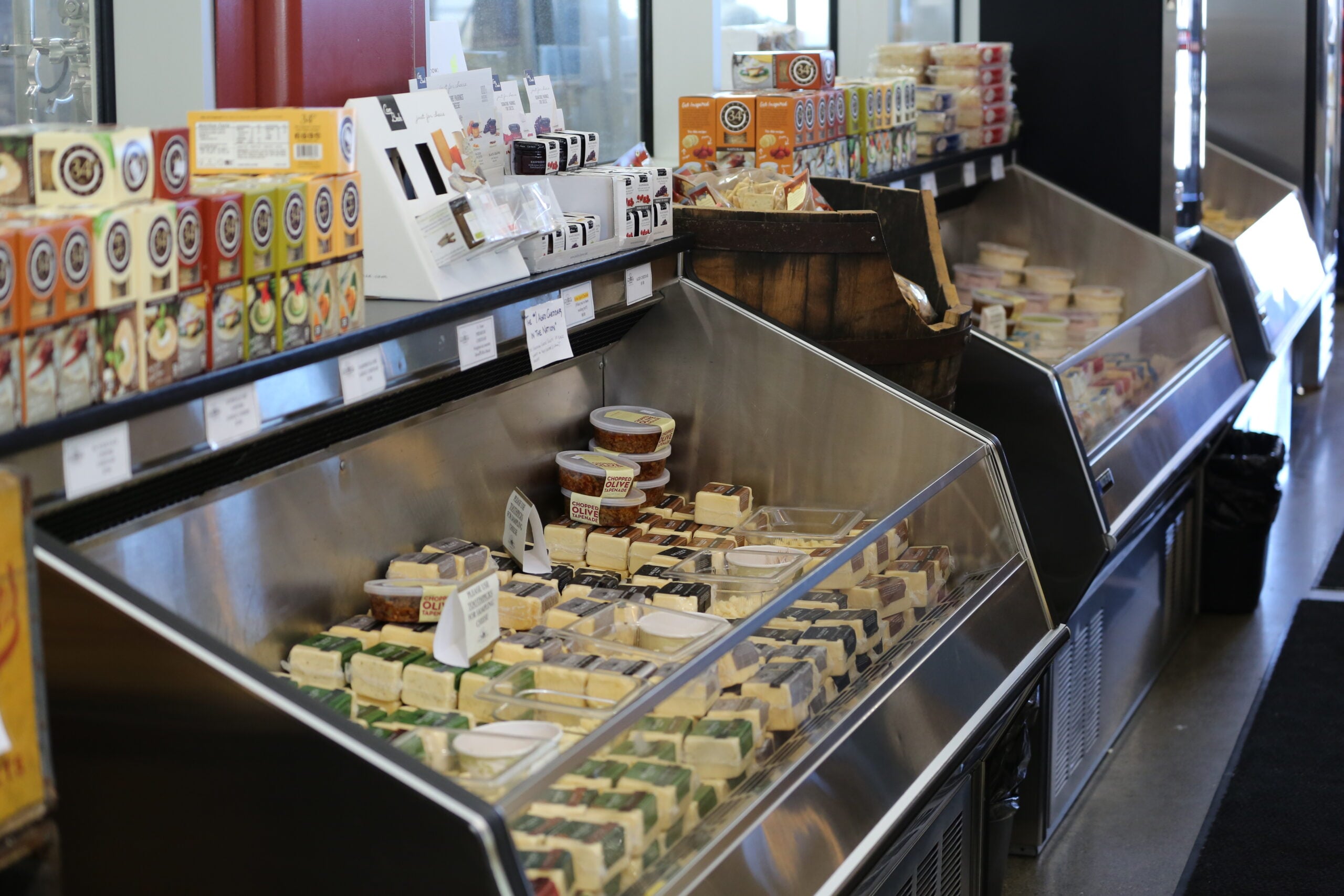 Cheeses displayed in a refrigerated case inside Face Rock Creamery in Bandon