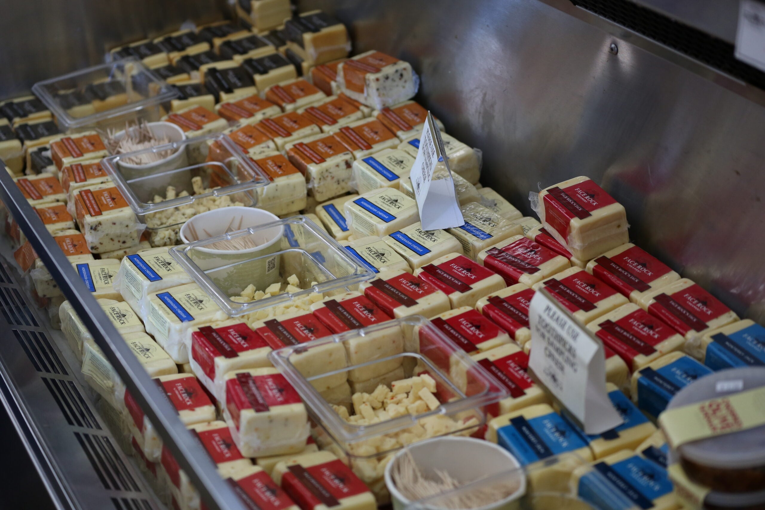 Packaged cheeses and curds displayed in the refrigerated case at Face Rock Creamery
