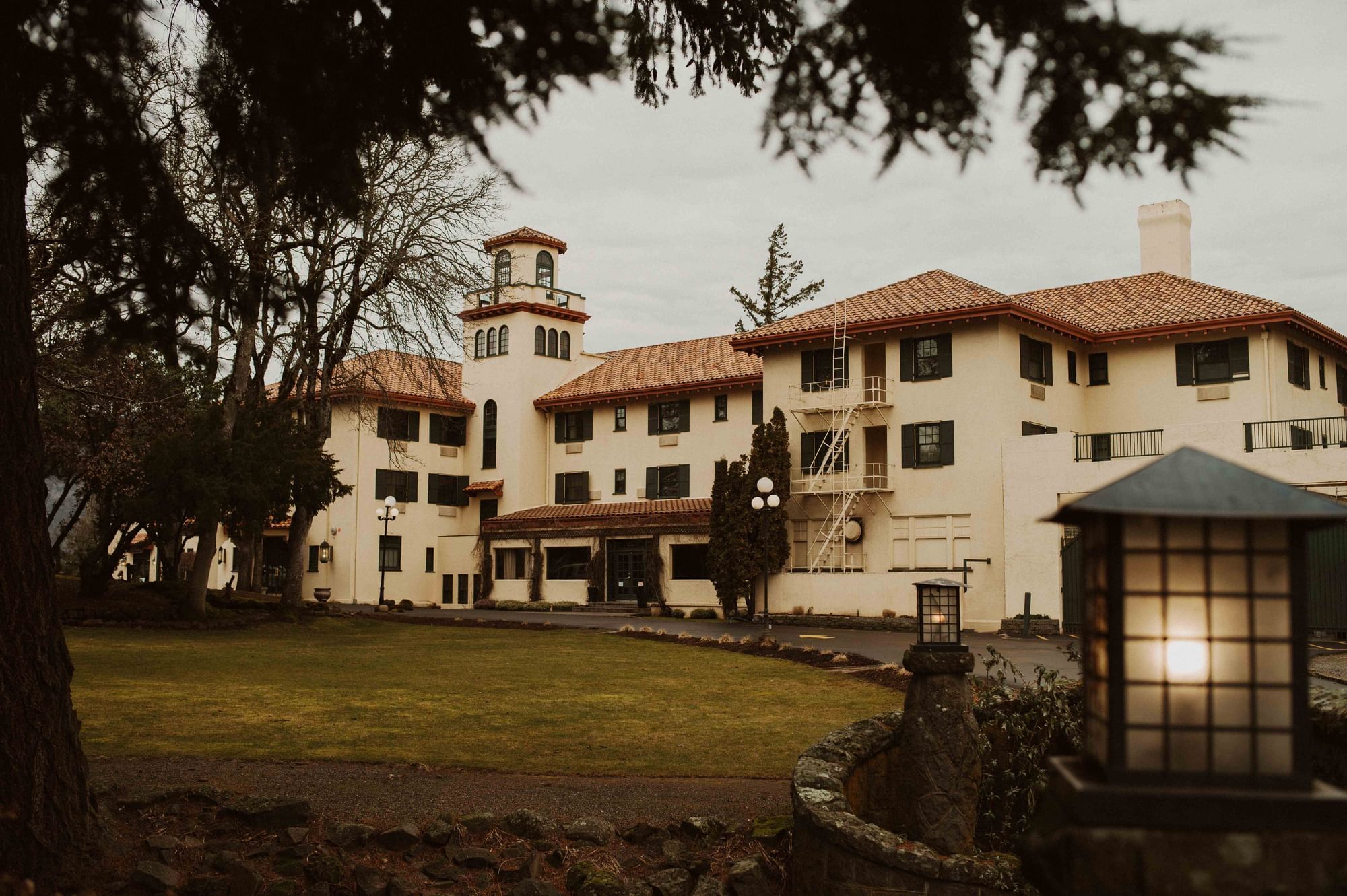 Columbia Gorge Hotel framed by trees above a garden pond.