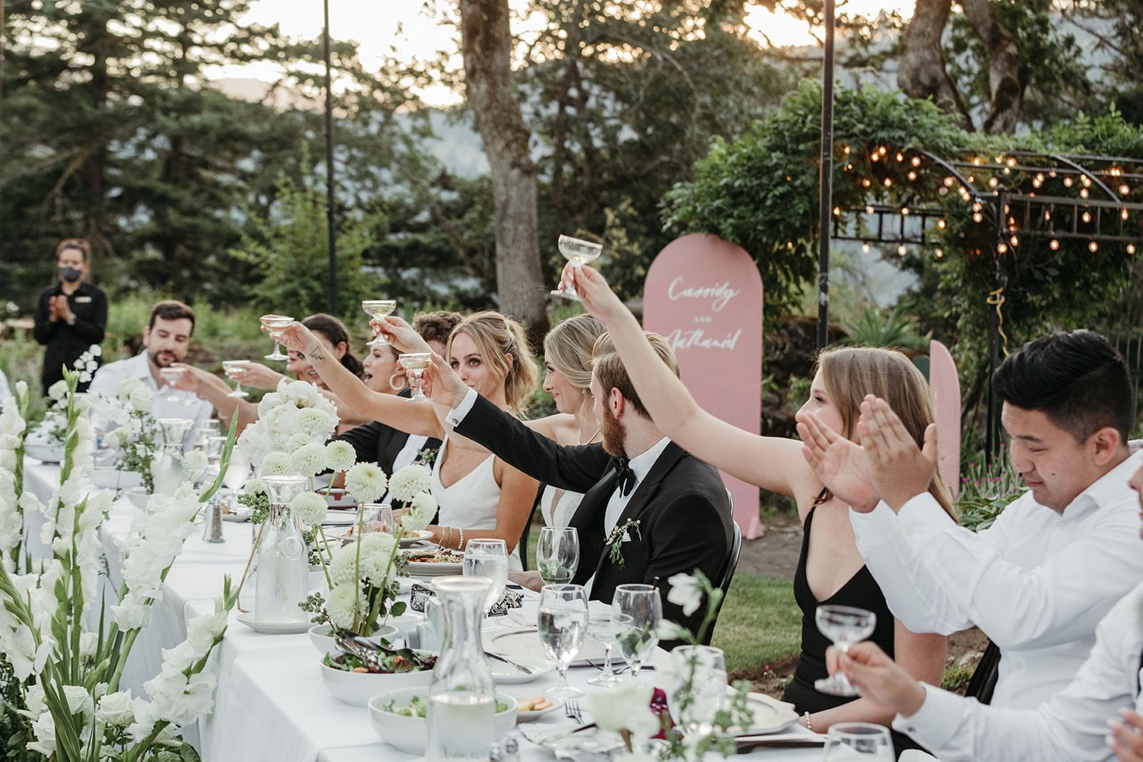 Guests raise their glasses at an outdoor Columbia Gorge Hotel wedding reception.