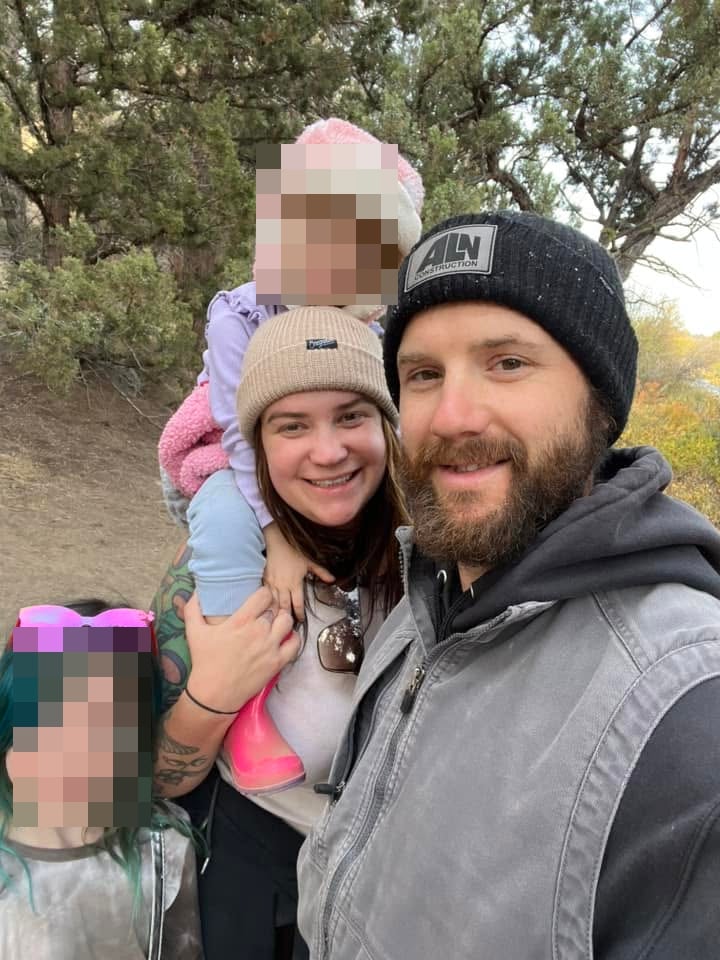 Kaylub and Kelsey Giamanco pose outdoors with their two daughters.