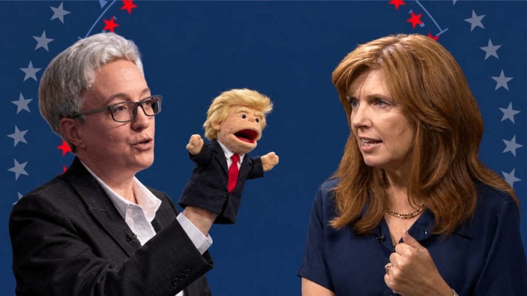 Kotek holds a Donald Trump puppet
