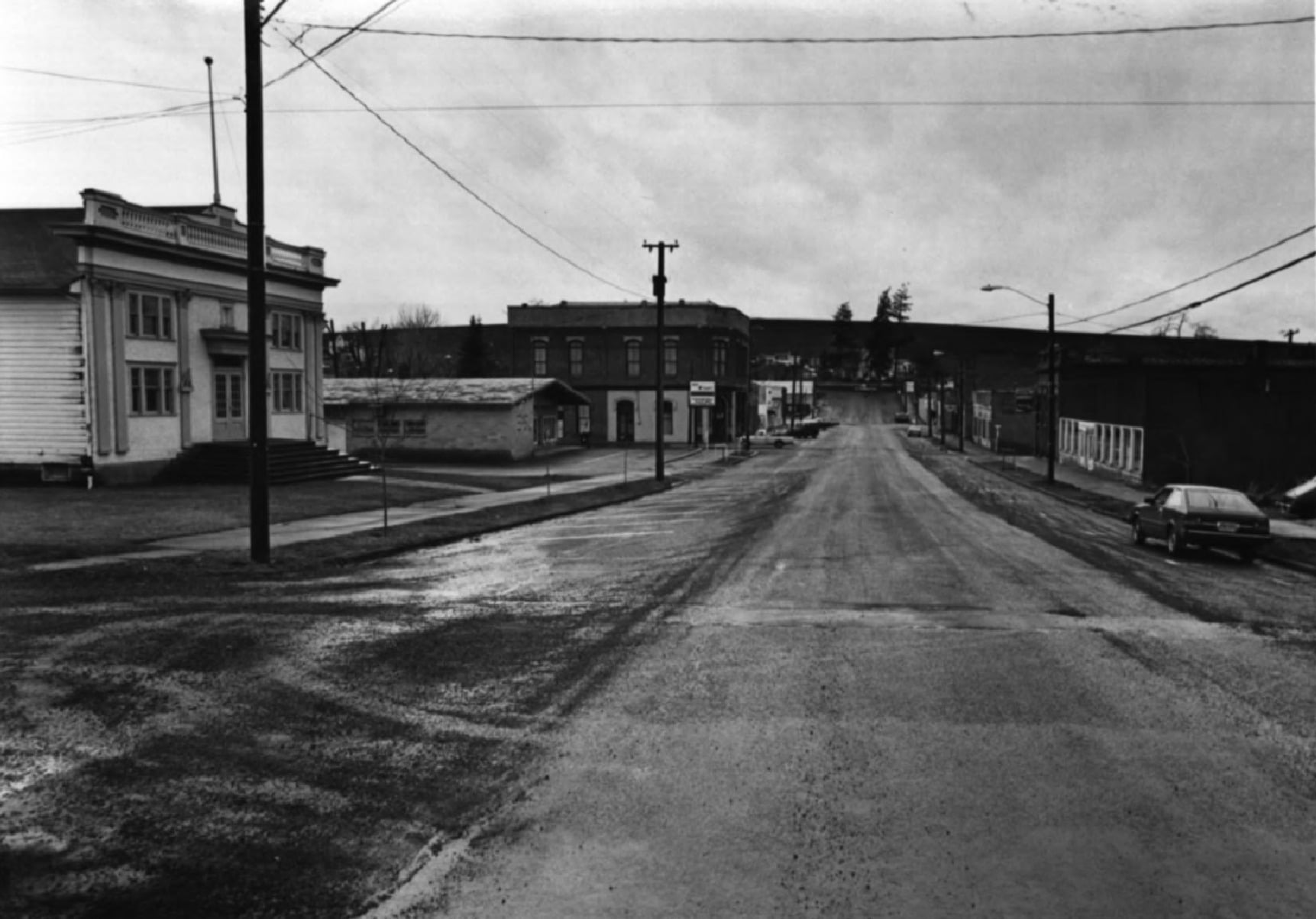 A black and white 1982 photograph looking west along Weston's Main Street past Memorial Hall and historic commercial buildings