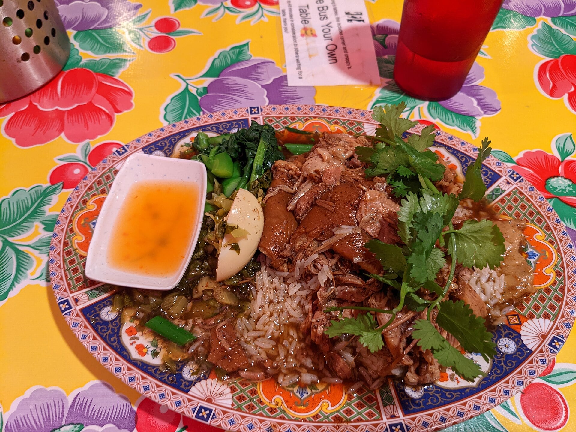 Pork and rice with a boiled egg, greens and pickled vegetables at Nong’s