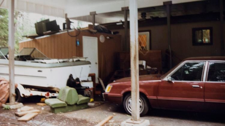 Archival police photograph of a covered carport at Rachanda Pickle's home, with a red car and stored household items.