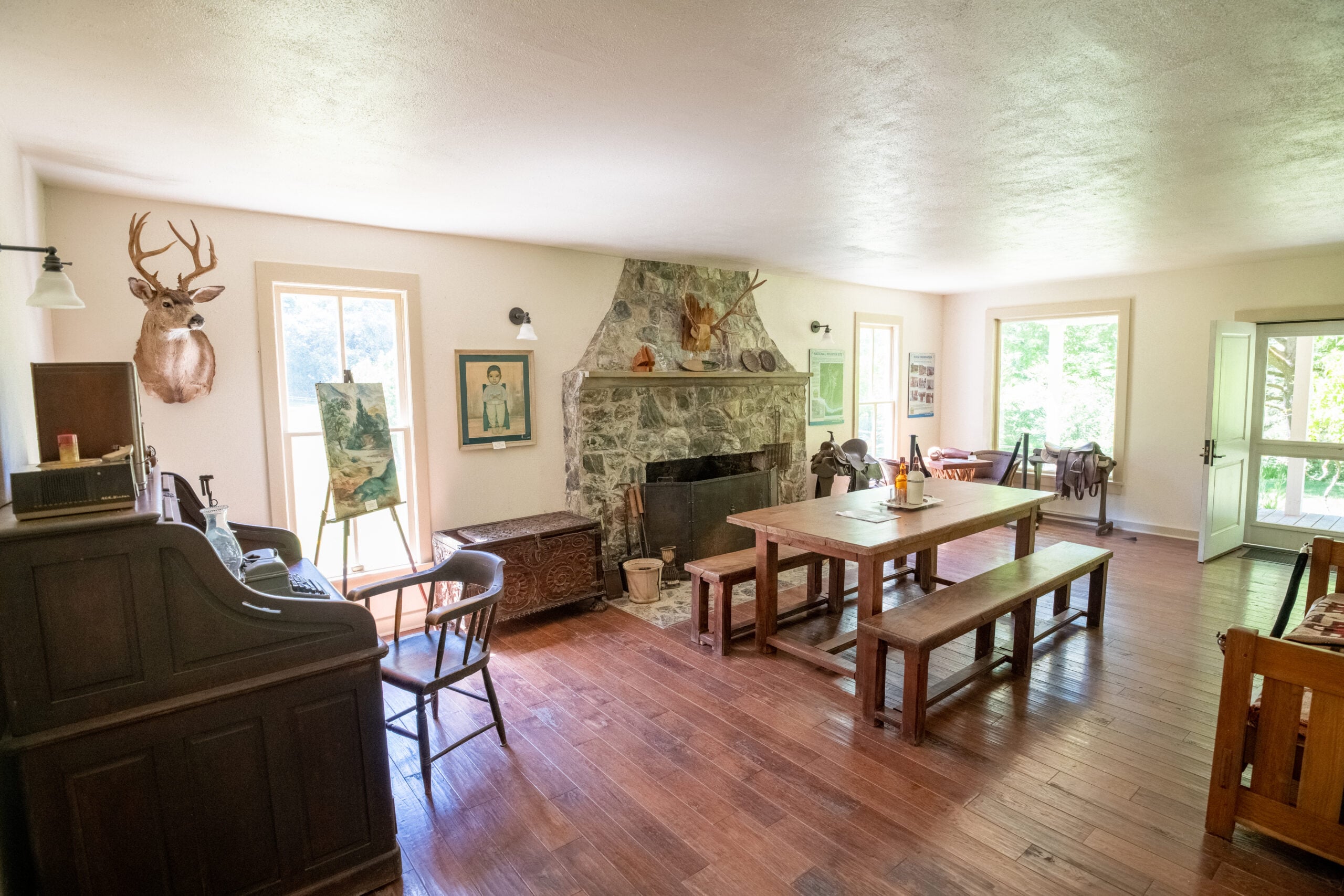 Wooden chairs, a dining table, a stove and historic furnishings in a room at Rogue River Ranch