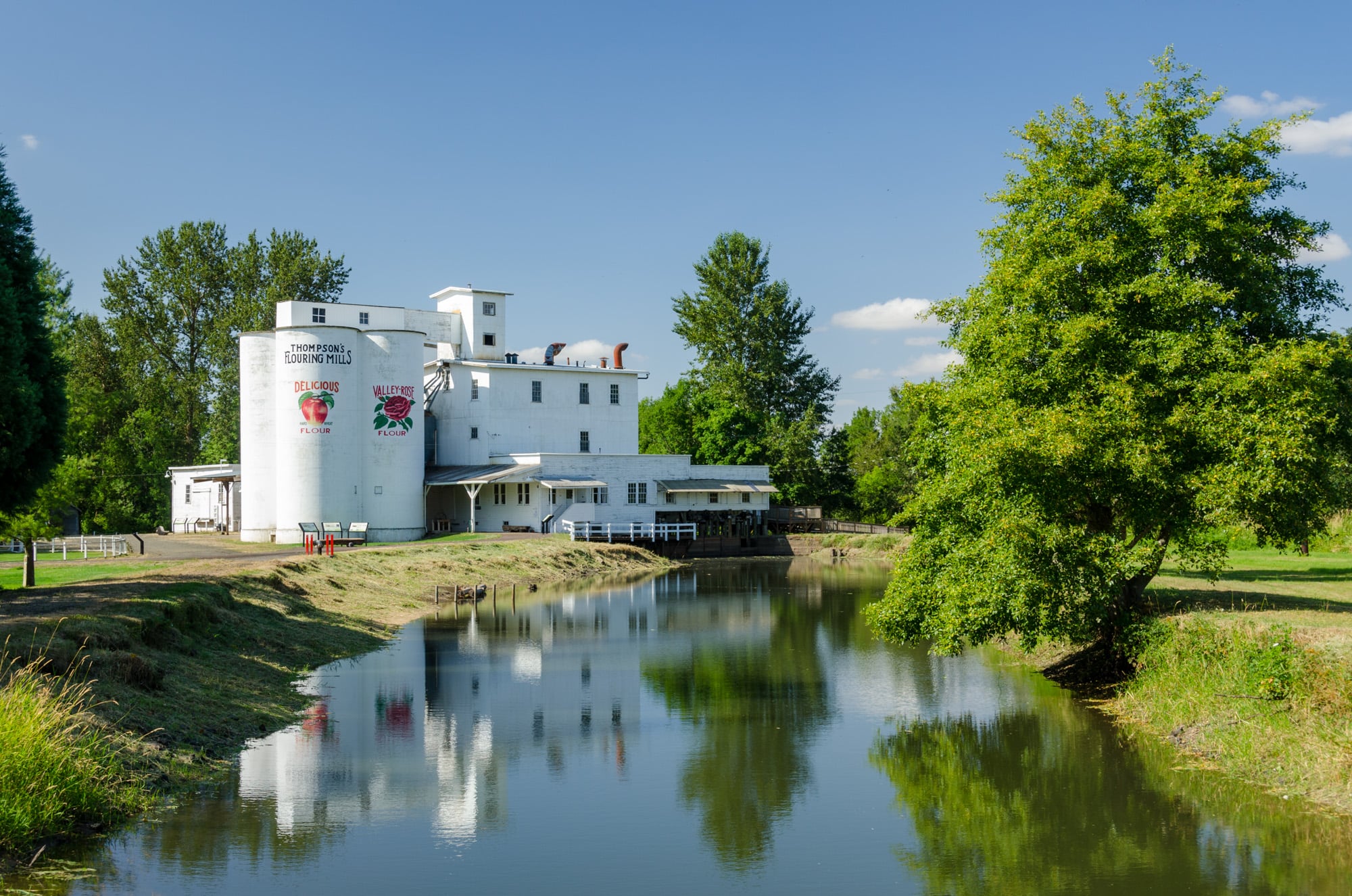 Thompson's Mills silos and white mill building beyond the water near Shedd, Oregon