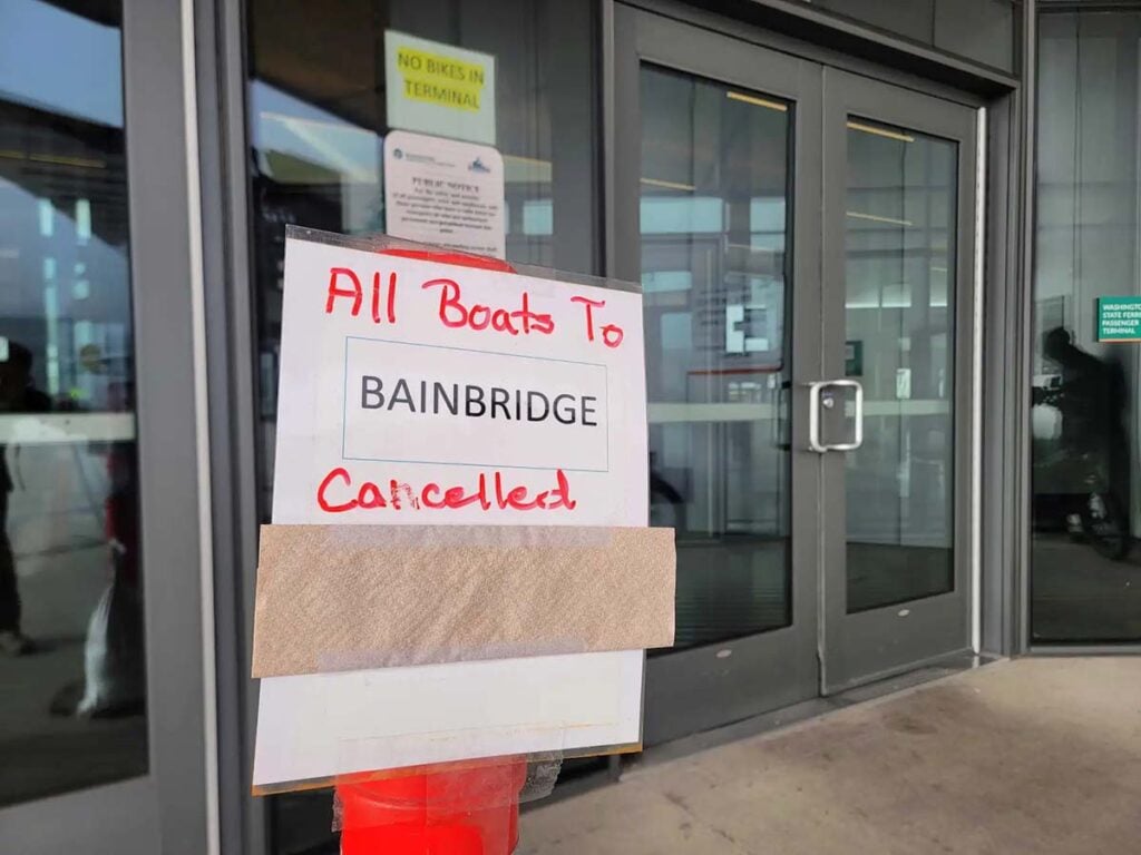 Sign outside a Washington State Ferries terminal reads “All boats to Bainbridge cancelled.”